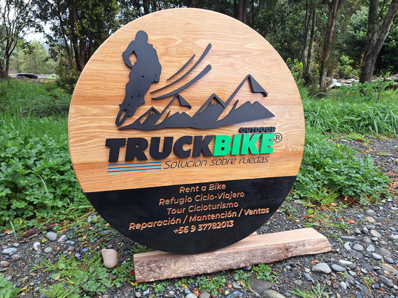 Truck Bike — Letrero de mañío con logotipo volumétrico y textos tallados.