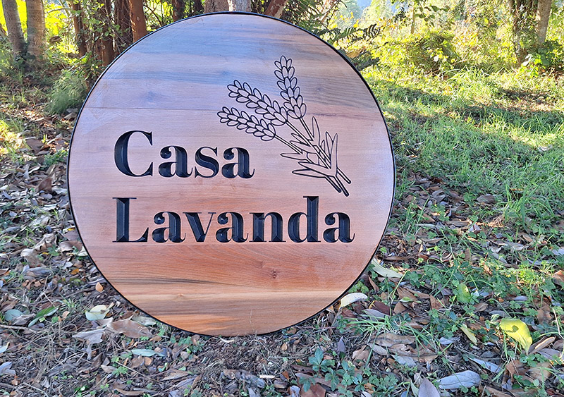 Casa Lavanda — Letrero circular tallado en roble.