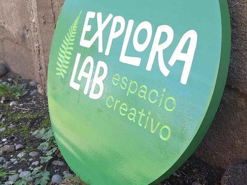Explora Lab — Letrero circular tallado en pino