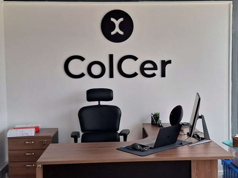 ColCer — Logo volumétrico de PVC espumado pegado sobre pared.