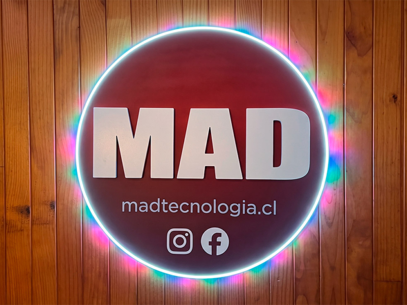 MAD Tecnología — Logo volumétrico, textos en vinilo. Luz neon en el borde y luz led de colores trasera.