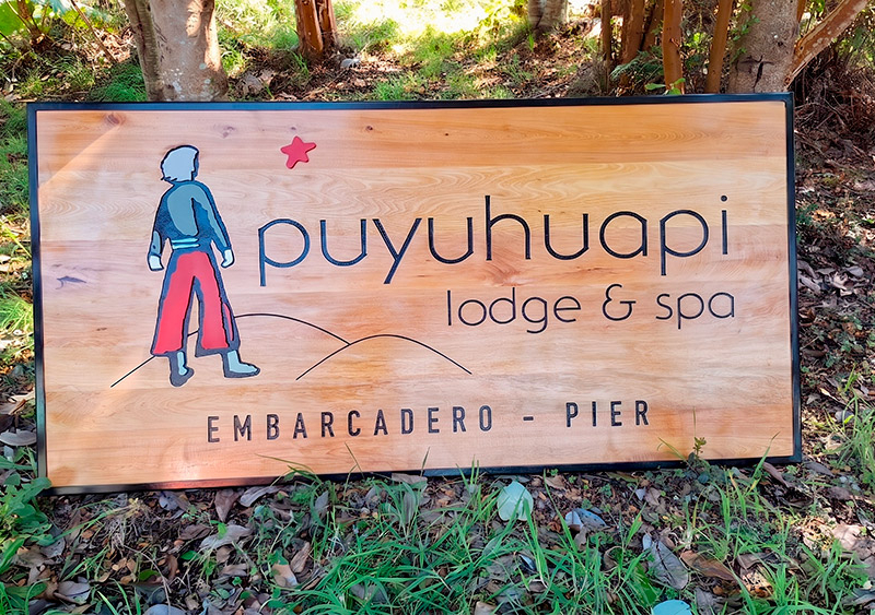 Puyuhuapi Lodge — Letrero de mañio con logo tallado y detalles en volumen