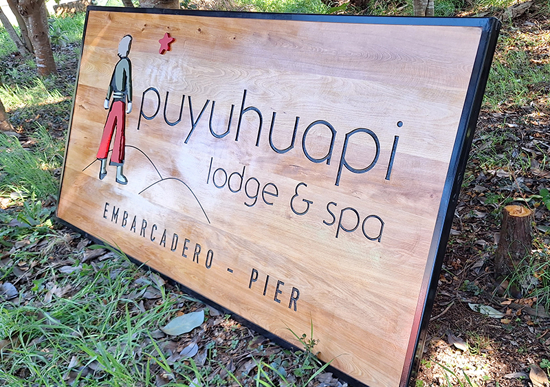 Puyuhuapi Lodge & Spa — Letrero tallado en mañío con detalles en volumen.